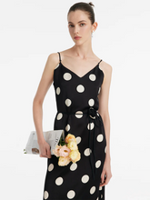 a lady in a polka dots printed spaghetti strap midi dress with rose belt